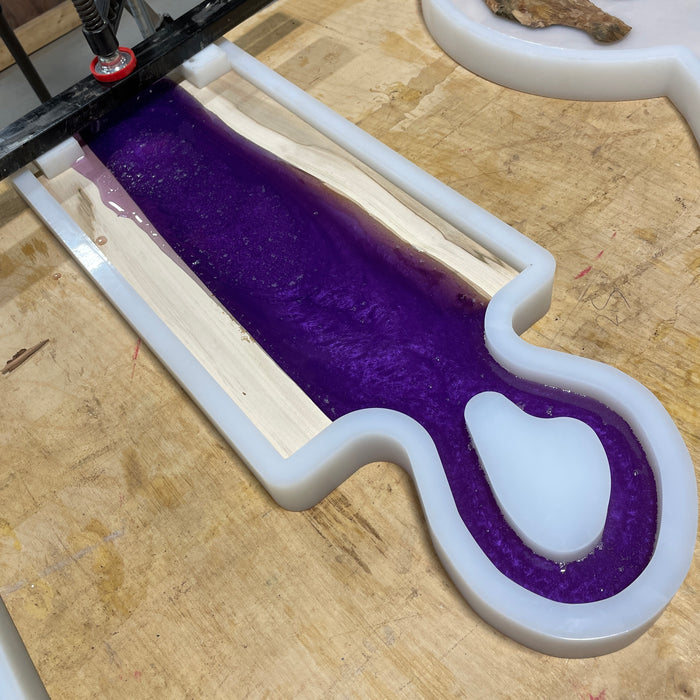 ambrosia maple pieces on the otter edges of the form with purple resin that has not been fully cured yet holding the pieces together 