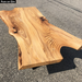 elm coffee table that has a live edge and voids filled with epoxy finished with pure oil finish