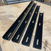 Four black metal brackets on a wooden surface