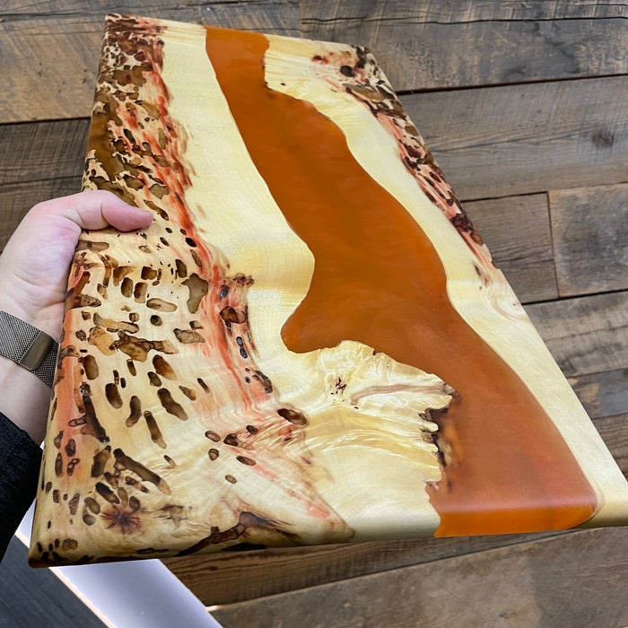 box elder burl wood with a half inch round over example piece to show an orange river running through it that was made from resin and coral mica powder pigment