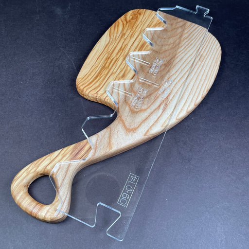 olive wood and ash charcuterie board with handle and acrylic clear template laying on top to show the potential of what can be made