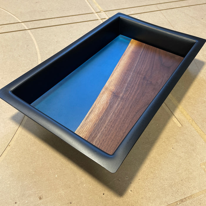 black rectangle form with a finished project inside showing walnut live edge and blue resin finished with an oil finish