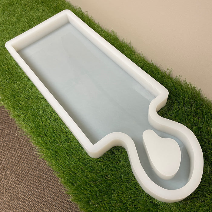 fake grass with a silicone mold on top that is rectangular shaped and has an organic shaped handle perfect for your diy projects