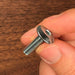 finger and thumb holding a small bolt showing you the profile on a slight angle