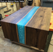 river table with a turquoise colour between two walnut slabs show a breathtaking example of what pure looks like when it is finished over top of wood and resin